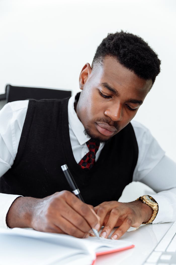 Focused businessman writing notes at his desk in an office.